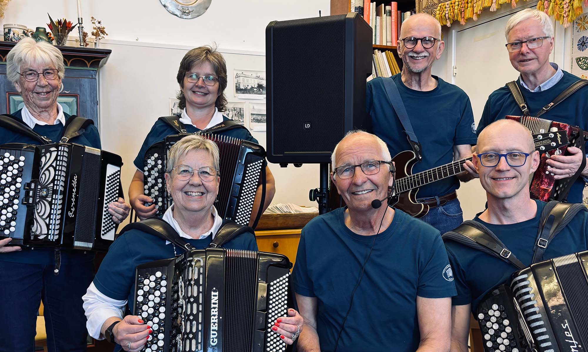 Kvinnor och män som ler och håller i instrument