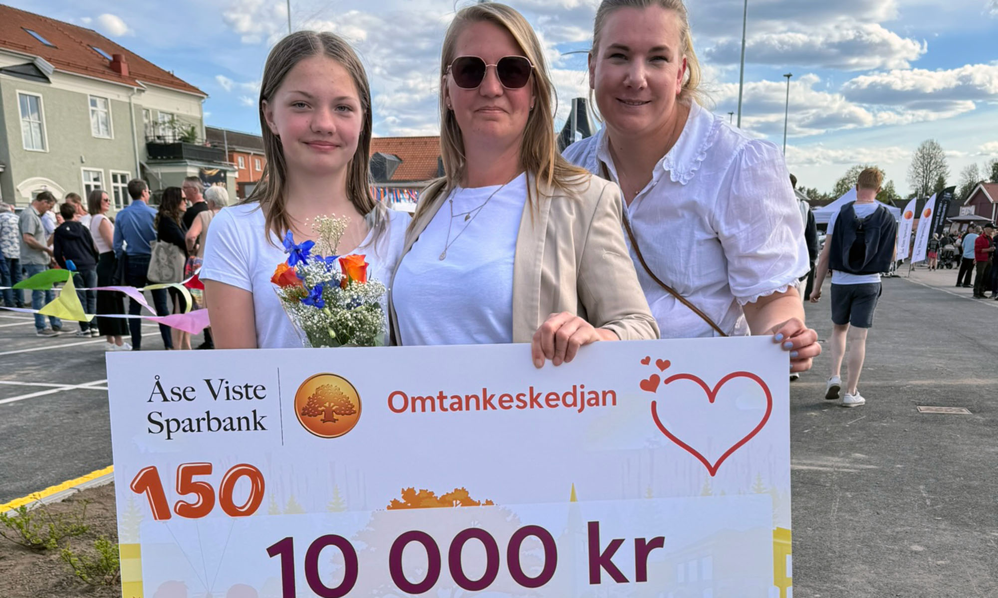 Tre kvinnor håller i en check
