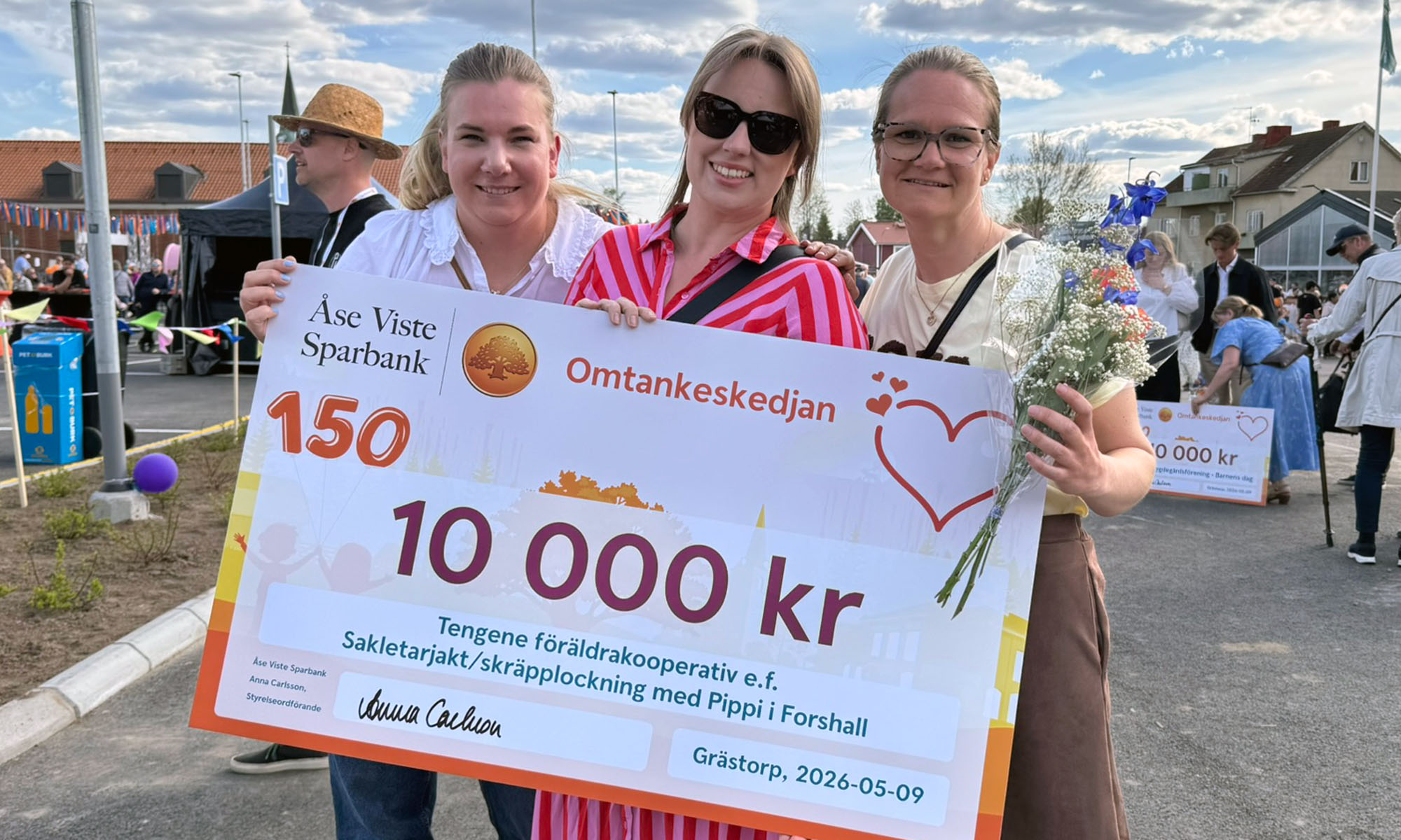 Tre kvinnor håller i en check