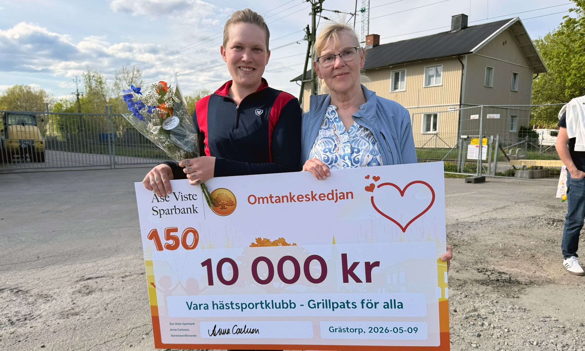 Två kvinnor håller i en check