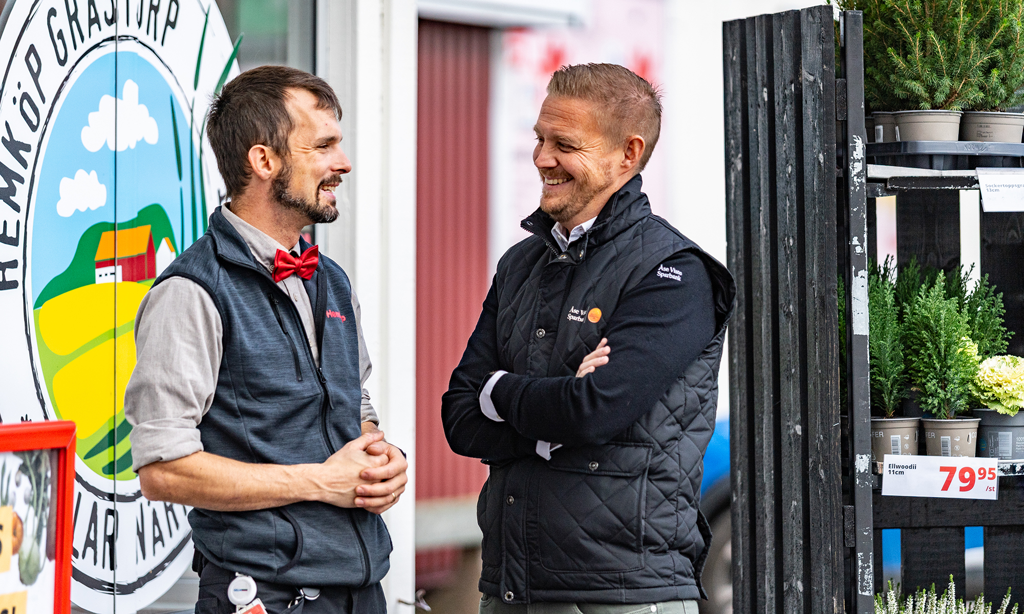 Två män står och pratar och är glada