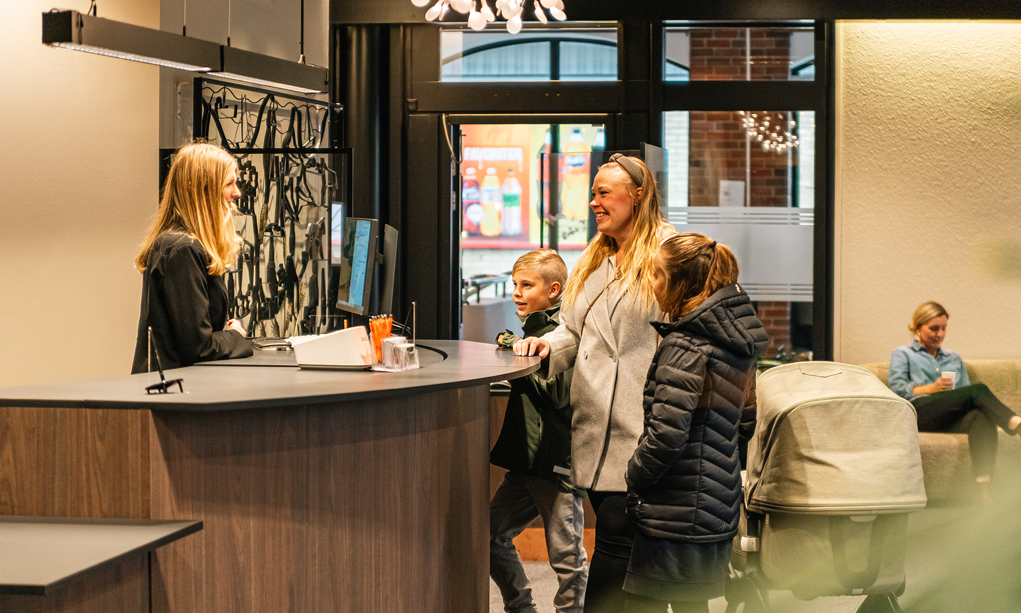 Kvinna med barn står vid kassan hos en bank