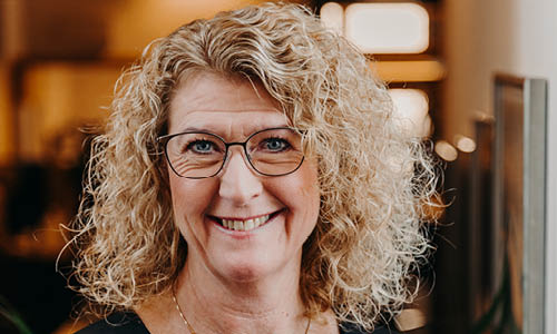 Kvinna ler in mot kameran