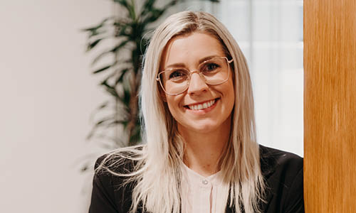 Glad kvinna lutar sig mot väggen