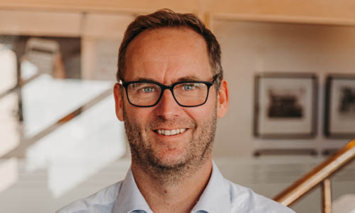 Man ler in i kameran