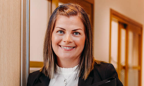 Kvinna lutar sig mot en dörrkarm